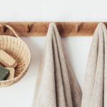 Pedestrian-Friendly Design - Wooden hanger with towels and basket with bathroom products