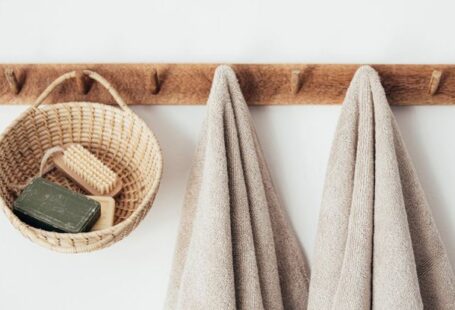 Pedestrian-Friendly Design - Wooden hanger with towels and basket with bathroom products
