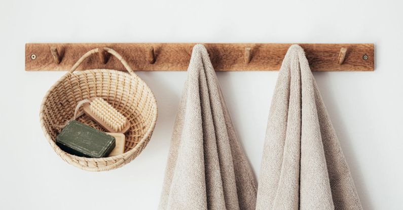 Pedestrian-Friendly Design - Wooden hanger with towels and basket with bathroom products