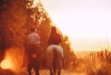 Car-Free Zones - Children riding stallions in countryside at bright sundown