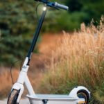 Sustainable Transportation - Photo of a Electric Scooter Standing on a Rural Side Way