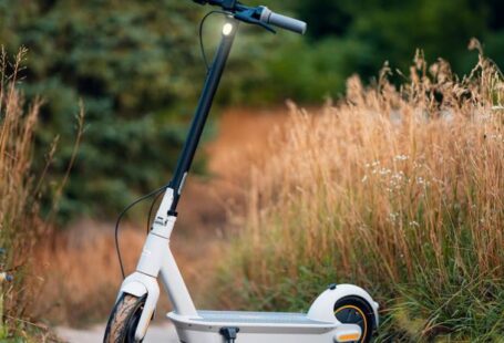 Sustainable Transportation - Photo of a Electric Scooter Standing on a Rural Side Way