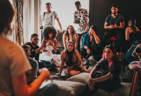 Community Events - Group of multiethnic people gathering around female speaker in studio