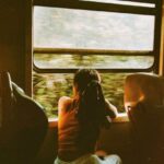 Public Transit - Unrecognizable woman riding train and looking out window