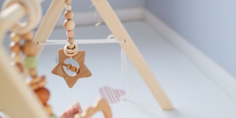 Tiny Homes - Cute toddler playing with wooden rattle