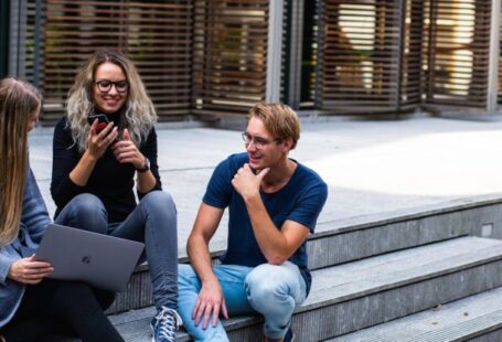 Millennials - Three Persons Sitting on the Stairs Talking With Each Other