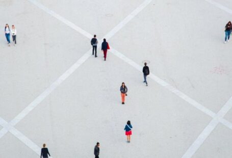 Public Squares - High angle citizens in casual wear walking on vast concrete ground in city square