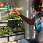 Food Banks - A black female activist looking at camera next to a food bank 